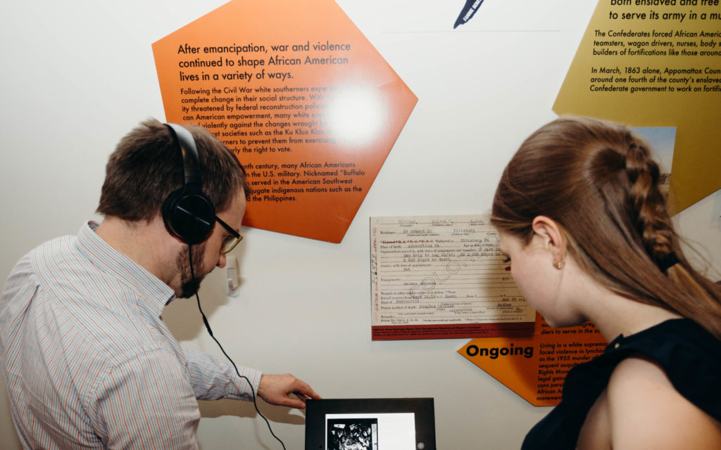 Two people reading exhibit information.