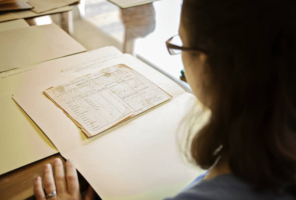 A woman carefully looking at a historical document.
