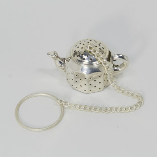 small metal tea infuser shaped like a tea pot, on a chain